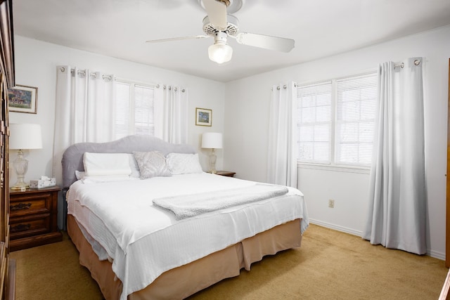 bedroom with light carpet, a ceiling fan, and baseboards