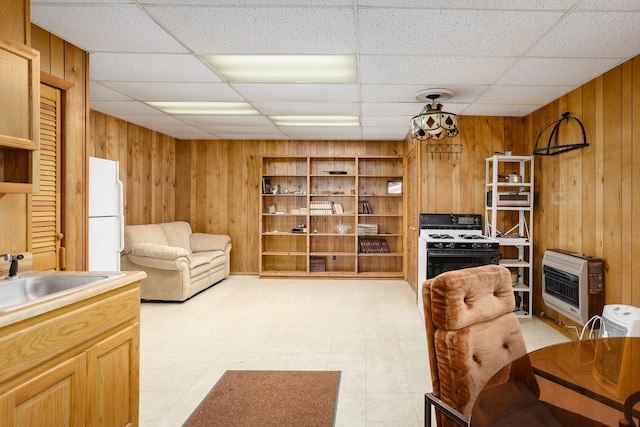 living room featuring heating unit, light floors, and wooden walls