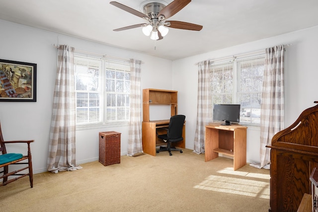 home office featuring light carpet and ceiling fan