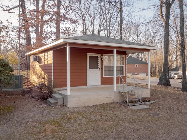 view of front of house featuring a shingled roof and an outdoor structure