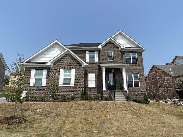 view of front facade featuring a front yard and brick siding