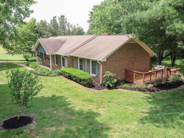 view of front of property with a front yard, brick siding, and a deck