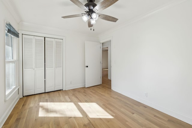 unfurnished bedroom featuring ornamental molding, a closet, light wood-style flooring, and baseboards