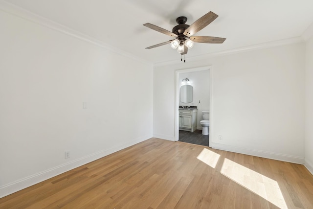 unfurnished room featuring ornamental molding, light wood-type flooring, and baseboards