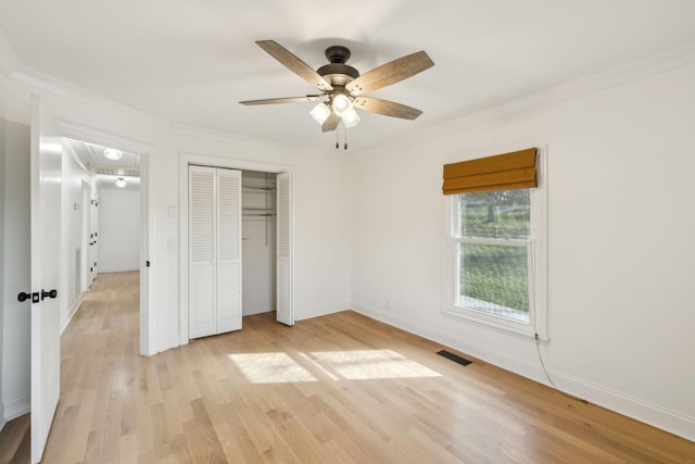 unfurnished bedroom with crown molding, baseboards, visible vents, and light wood-style floors