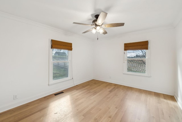 unfurnished room with plenty of natural light, visible vents, ornamental molding, and light wood-style flooring