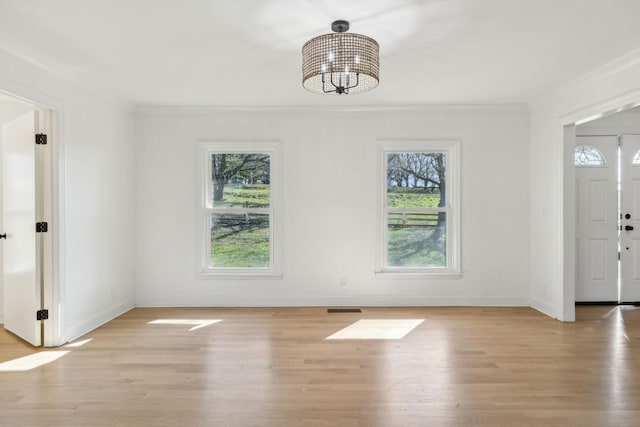 unfurnished dining area with a notable chandelier, light wood-style flooring, visible vents, and crown molding