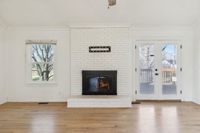 unfurnished living room featuring french doors, wood finished floors, visible vents, and crown molding