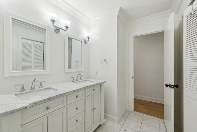 bathroom with ornamental molding, a sink, baseboards, and double vanity