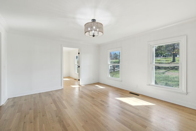 unfurnished dining area with visible vents, baseboards, light wood-type flooring, an inviting chandelier, and crown molding