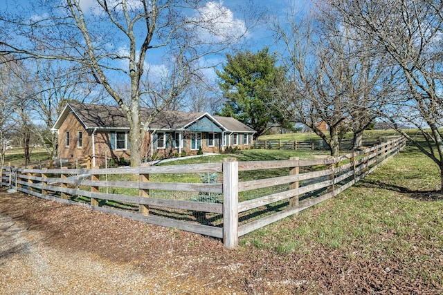 ranch-style house featuring brick siding, a fenced front yard, and a front yard