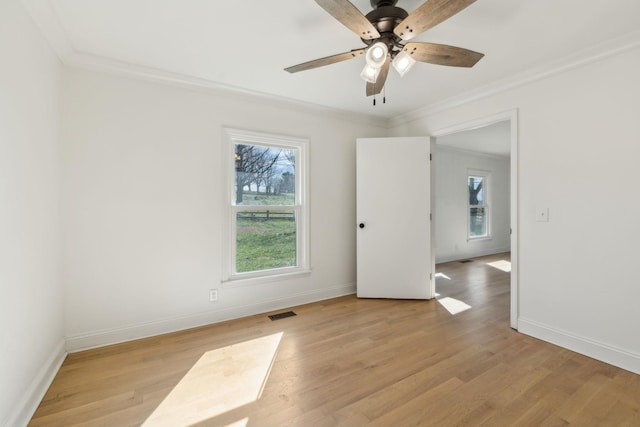 unfurnished room with ornamental molding, baseboards, and light wood finished floors