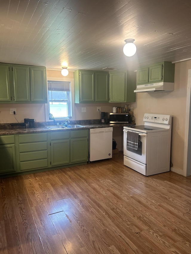 kitchen featuring under cabinet range hood, white appliances, dark wood-type flooring, a sink, and green cabinetry