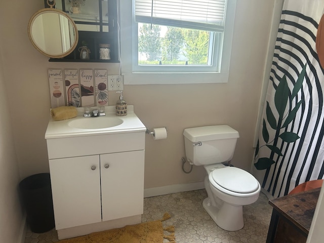 bathroom with a shower with shower curtain, baseboards, vanity, and toilet