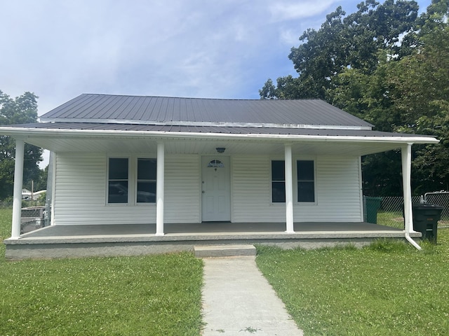 bungalow-style house with metal roof, a porch, and a front yard