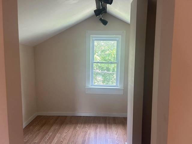 bonus room featuring vaulted ceiling, baseboards, and wood finished floors