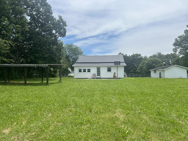 back of property with metal roof and a lawn