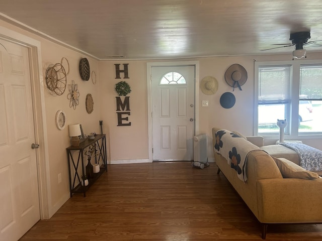 foyer entrance with dark wood-style floors, baseboards, a ceiling fan, and radiator