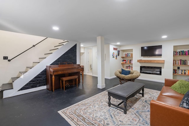 living area with stairs, concrete floors, a glass covered fireplace, and built in features