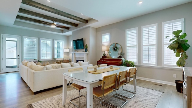 living room with plenty of natural light, light wood finished floors, a fireplace, and baseboards