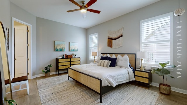 bedroom with ceiling fan, baseboards, and wood finished floors