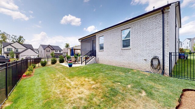 view of yard featuring a patio area, a fenced backyard, and a residential view