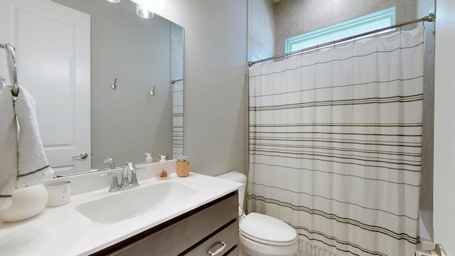 bathroom with curtained shower, vanity, and toilet