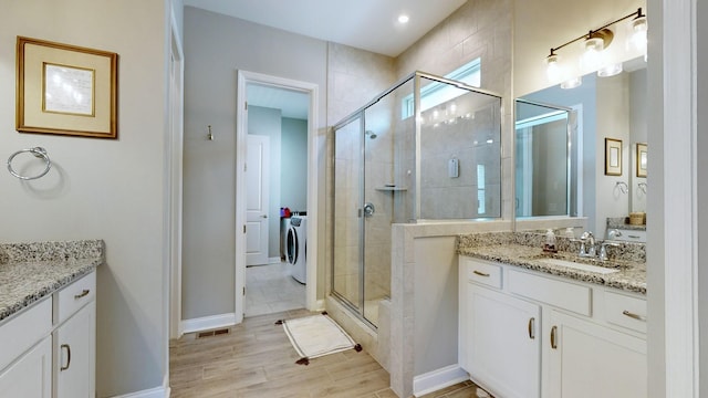 bathroom with wood finished floors, visible vents, vanity, baseboards, and a shower stall