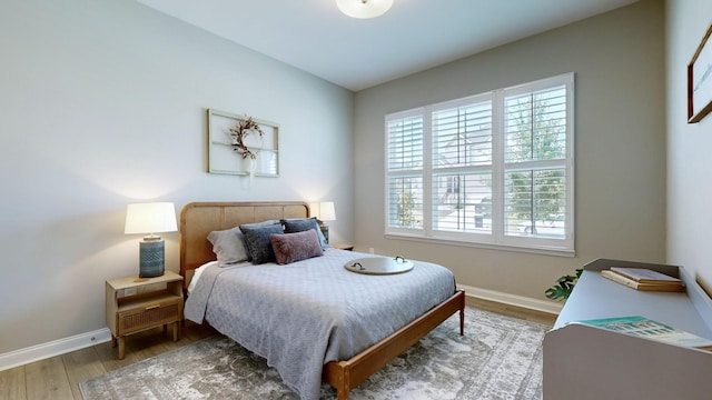 bedroom with baseboards and wood finished floors