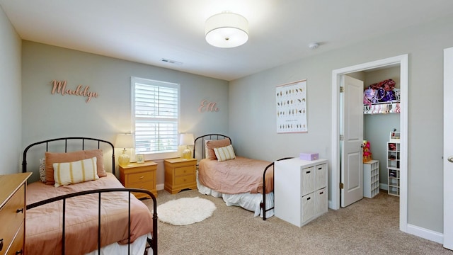 bedroom featuring a closet, visible vents, a spacious closet, light carpet, and baseboards