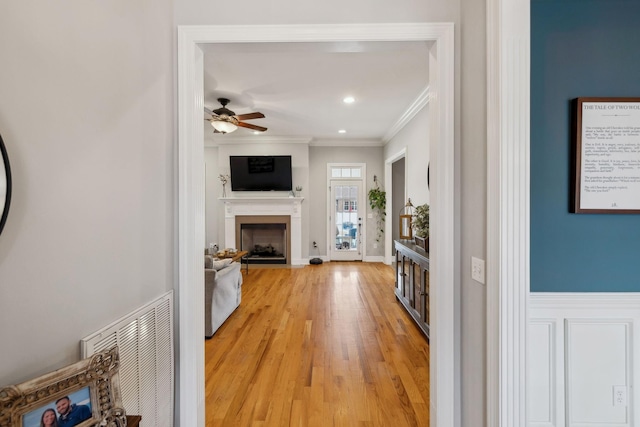 hall featuring recessed lighting, visible vents, baseboards, light wood finished floors, and crown molding