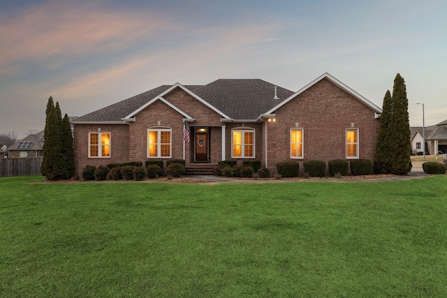 single story home featuring brick siding, a front lawn, and fence