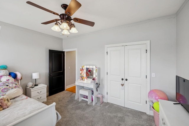 bedroom with a ceiling fan, a closet, and light colored carpet