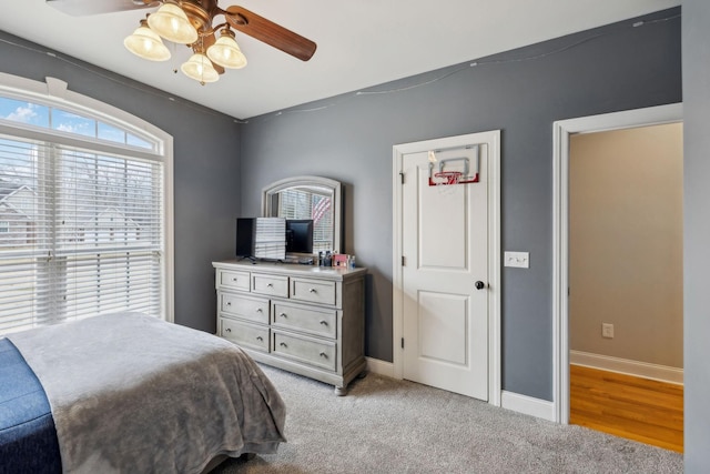 bedroom featuring ceiling fan, baseboards, and light colored carpet