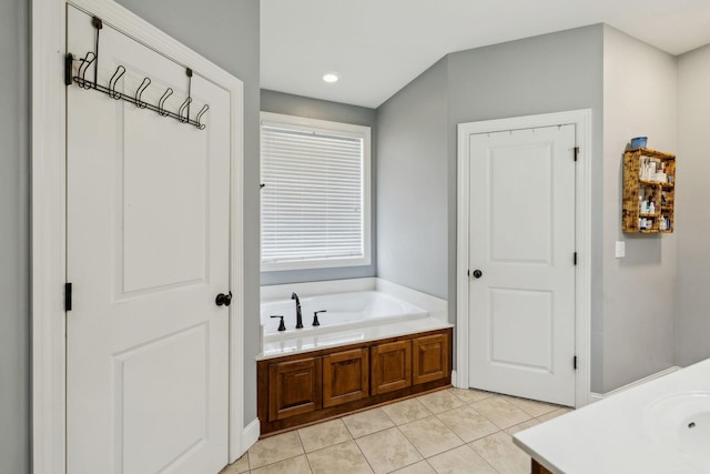 bathroom featuring tile patterned flooring, vanity, and a bath