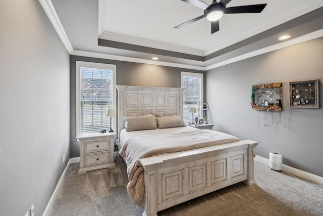 bedroom featuring dark colored carpet, a raised ceiling, and baseboards