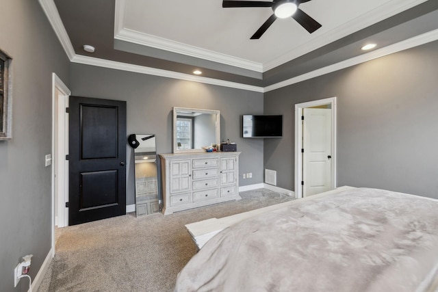 carpeted bedroom featuring a tray ceiling, visible vents, ornamental molding, ceiling fan, and baseboards