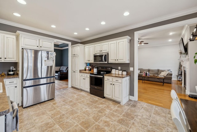 kitchen with ornamental molding, ceiling fan, appliances with stainless steel finishes, and a fireplace