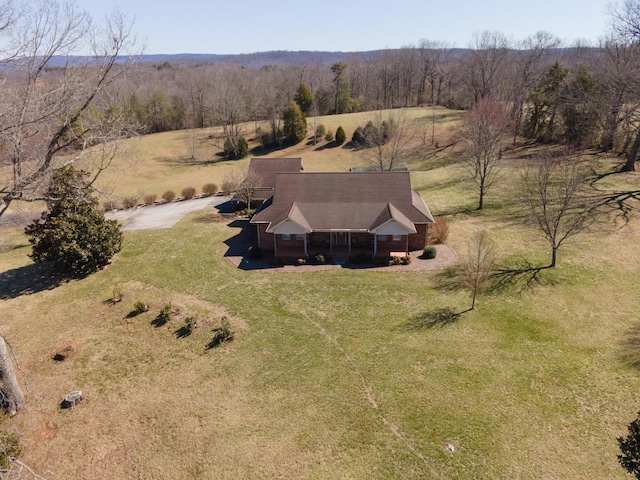 drone / aerial view featuring a view of trees and a rural view