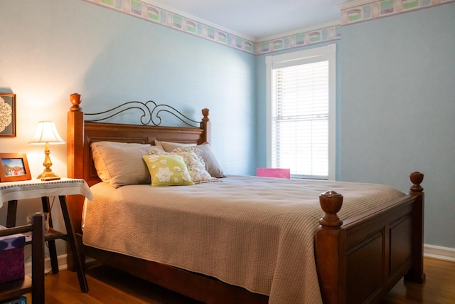 bedroom featuring baseboards and wood finished floors