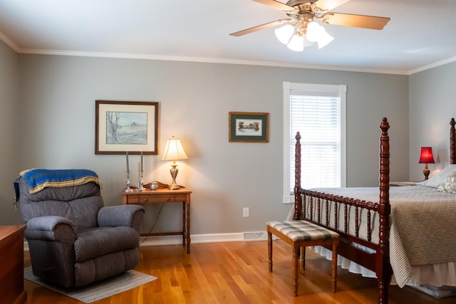 bedroom featuring baseboards, visible vents, a ceiling fan, ornamental molding, and light wood-style floors