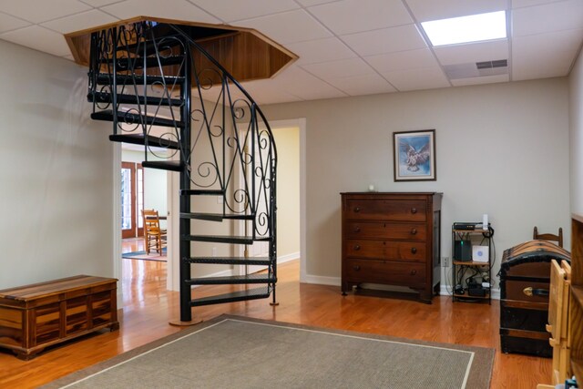 stairs featuring a drop ceiling, wood finished floors, and baseboards