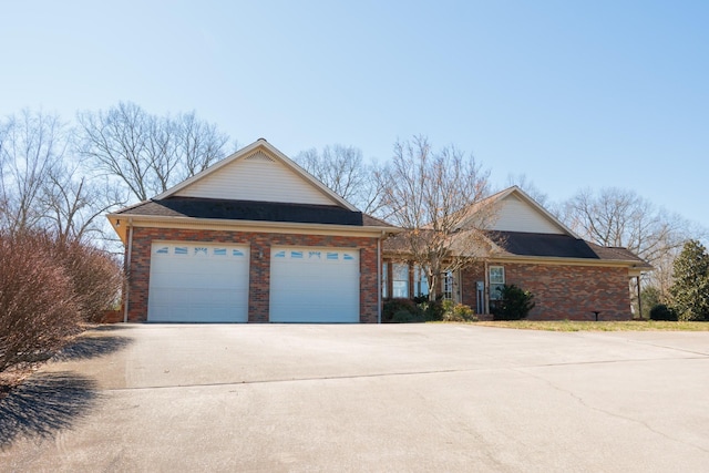 view of front of house with concrete driveway, brick siding, and an attached garage