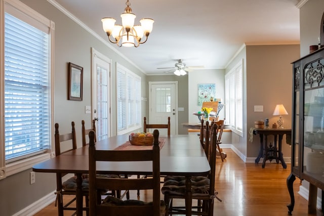 dining room with plenty of natural light, crown molding, and wood finished floors