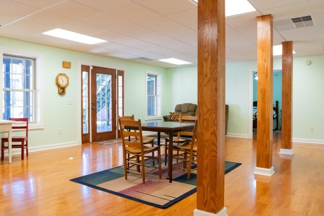 dining room with baseboards, visible vents, a drop ceiling, and wood finished floors