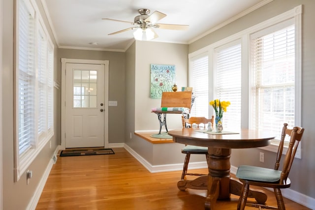 entryway with a healthy amount of sunlight, light wood-style floors, baseboards, and crown molding