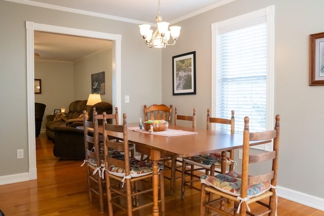 dining room featuring ornamental molding, wood finished floors, a wealth of natural light, and baseboards