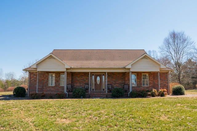 ranch-style home with brick siding, a porch, and a front yard