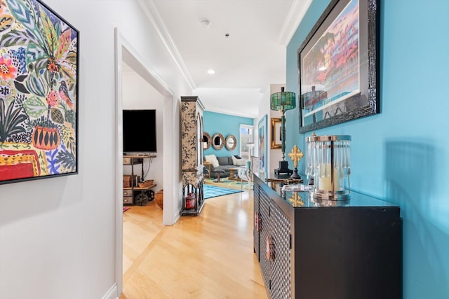 hallway featuring light wood-type flooring, crown molding, and recessed lighting