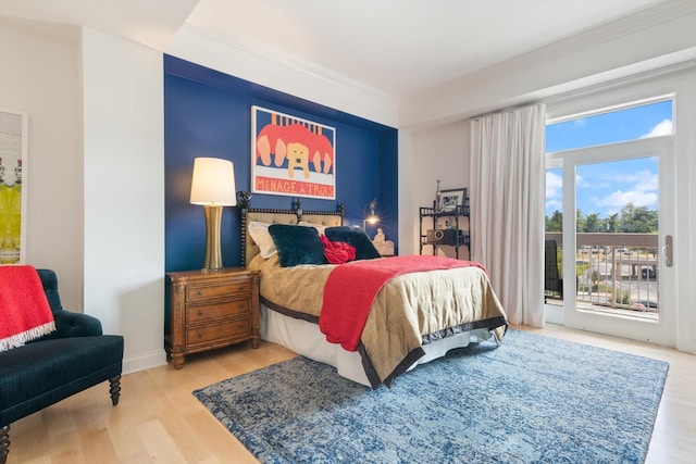 bedroom featuring access to outside, crown molding, baseboards, and wood finished floors